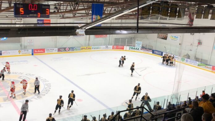 The Olds Grizzlys celebrate with goaltender Corbin Sanderman after beating the reigning Centennial Cup champions on November 7, 2025. (Galen Hartviksen, mymountainviewnow.com staff)