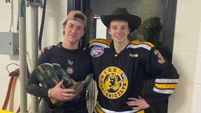 L-R: Aaron Sawatzky from Didsbury receives the Hardest Worker Boots and Owen Hutzul from Edmonton wears the Player of the Game Hat following a 5-4 win for the Olds Grizzlys over the Lloydminster Bobcats on December 6, 2025. (Supplied - Olds Grizzlys, Mark Payne @hockeypayne)